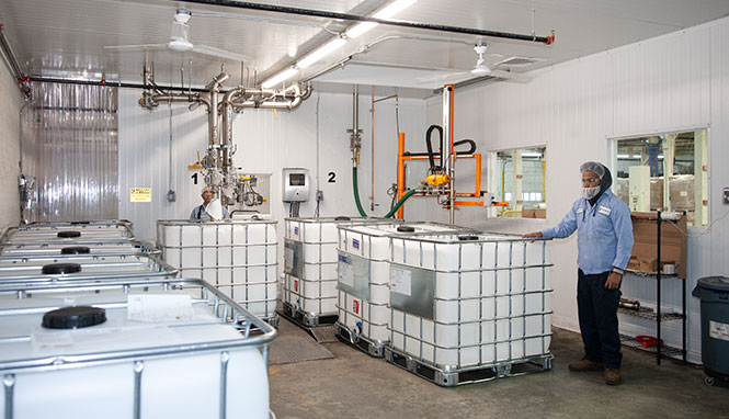 IBC tanks in a warehouse room with employee