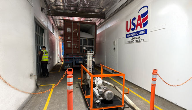 image of a pump extracting liquids from a flexitank in a truck trailer inside a warehouse bay